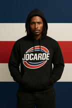 Person wearing a black hoodie with 'JOCARDE' logo against a red, white, and blue striped background